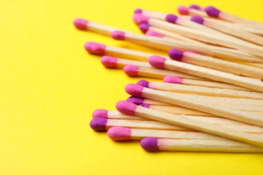 Sarı arka planda farklı yeni kibrit çöpleri, yakın plan