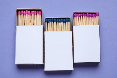 Mor zemin üzerinde farklı kibrit çöpleri olan kutular