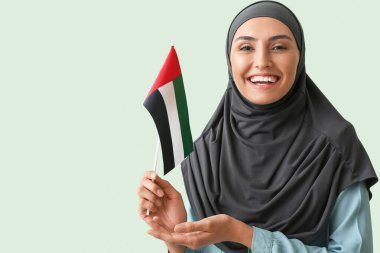 Yeşil arka planda BAE bayrağı olan güzel Müslüman kadın.