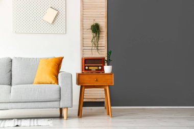 Oturma odasında eski radyo alıcısı ve saksısı olan ahşap masa.