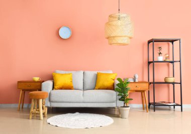 Kanepesi, ahşap masaları ve raf ünitesi olan şık bir oturma odası.