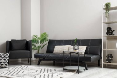 Siyah koltuğu ve kanepesi olan modern bir oturma odası.