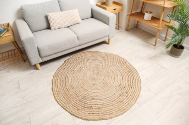 Rahat kanepesi ve ahşap zeminde hasır halısı olan bir oturma odası.