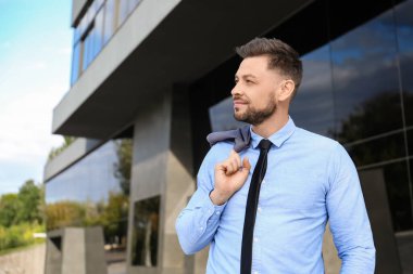 Ofis binası yakınlarında yakışıklı bir işadamı.