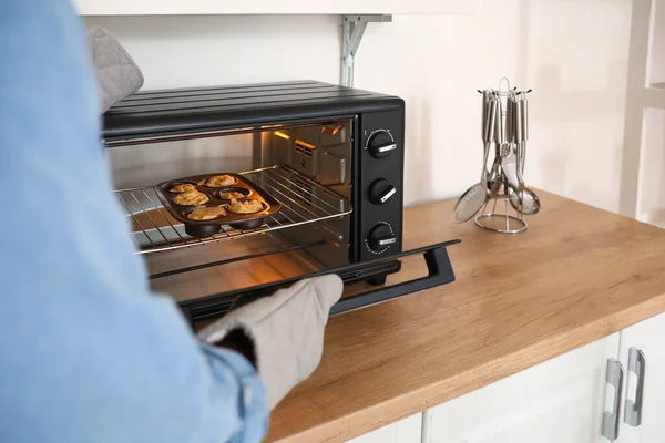 Anak Muda Menaruh Muffin Persik Mentah Dalam Oven Dapur — Stok Foto