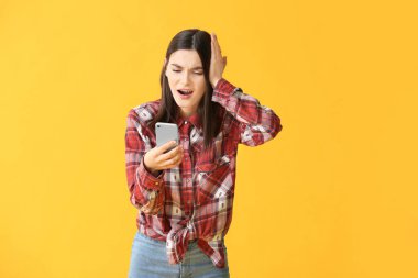 Arka planda cep telefonu olan sorunlu genç bir kadın.