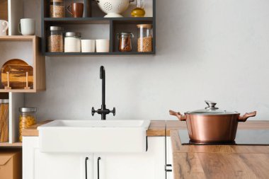 Mutfakta ocak üzerinde parlak bir tencere.