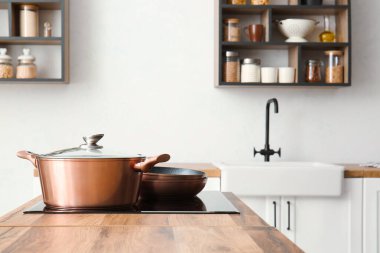 Işıl ışıl tencere ve tavalar hafif mutfakta fırında.