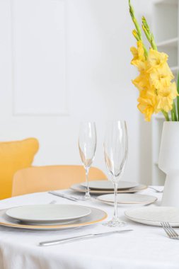 Tabaklar, boş bardaklar ve masadaki Gladiolus çiçekleri.