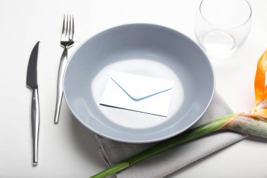 Cennet kuşu çiçekli basit bir masa ve beyaz arka planda bir zarf.