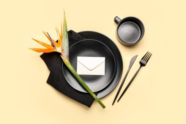 Cennet kuşu çiçekli basit bir masa ve sarı arka planda bir zarf.