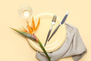 Sarı arka planda cennet kuşu çiçekli basit bir masa.