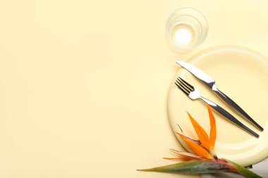 Sarı arka planda cennet kuşu çiçekli basit bir masa.