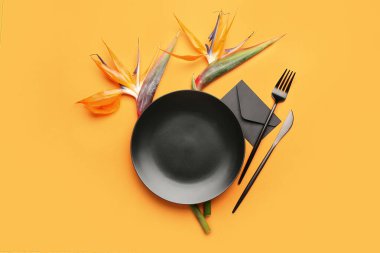 Turuncu arka planda cennet kuşu çiçekleri olan basit bir masa.