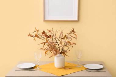 Renk duvarına yakın sonbahar dekorlu güzel bir masa ve vazo.