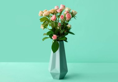 Yeşil arka planda küçük güller olan vazo