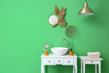 Beyaz masalı, lavabolu ve aynalı şık bir banyo.