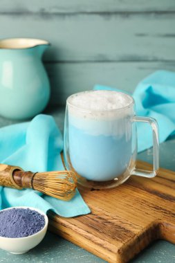 Ahşap tahta tahta bir bardak mavi kibrit latte, toz ve kestane renkli ahşap zemin