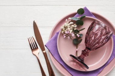 Şık masa düzenleme ve açık ahşap arka planda çiçekler