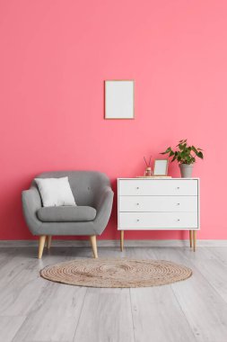 Rahat koltuk, sandık dolusu çekmece ve şık bir oda içinde hasır halı.