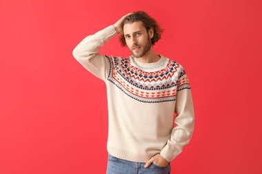 Renkli süveter giyen yakışıklı bir genç.