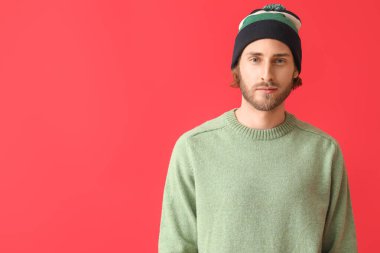 Renkli süveter giyen yakışıklı bir genç.