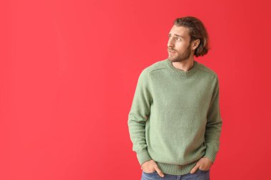 Renkli süveter giyen yakışıklı bir genç.