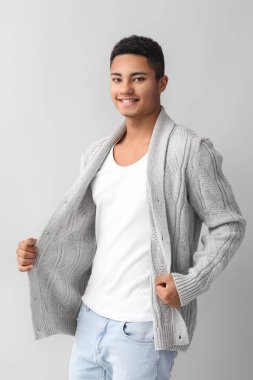 Hafif arka planda örgü süveter giyen yakışıklı Afro-Amerikalı adam.