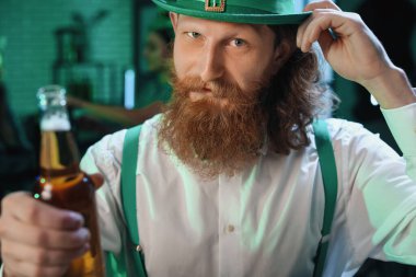 Aziz Patrick Günü 'nde barda elinde bira şişesiyle sakallı bir adam.