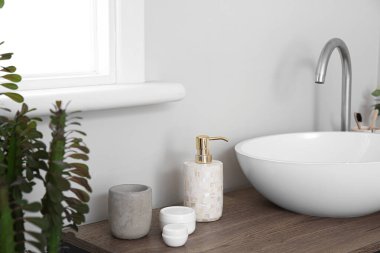 Banyo aksesuarları, mum ve lavabo ışık duvarının yanındaki masada.