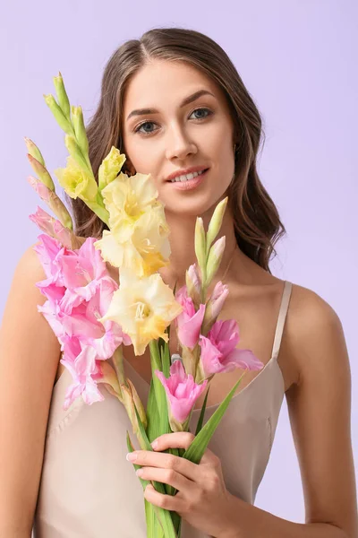 若いです女性保持花束の美しいグラジオラス花上の色の背景 — ストック写真