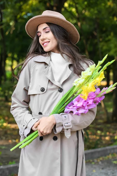 Leende Modern Kvinna Med Bukett Gladiolus Blommor Parken — Stockfoto