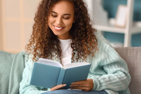 Young African American Woman Warm Cardigan Reading Book Sofa Home — Stock Photo, Image