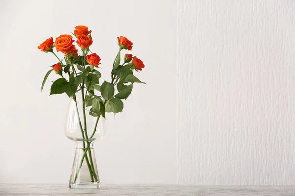 Βάζο Όμορφα Πορτοκαλί Τριαντάφυλλα Στο Τραπέζι Ενάντια Στο Φως Τοίχο — Φωτογραφία Αρχείου