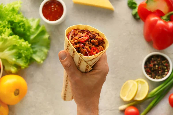 Man Holding Tasty Burrito Grey Background — Stock Photo, Image