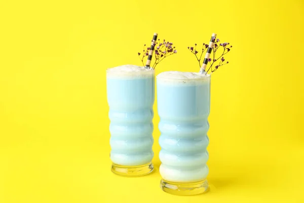 蓝色马沙拿铁玻璃杯和黄色背景的花 — 图库照片