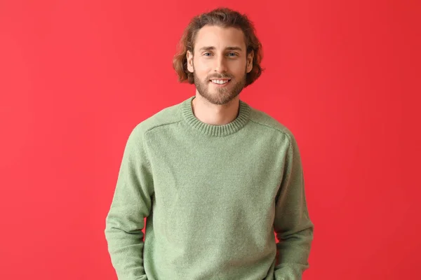ハンサムな若いです男でニットセーター上の色の背景 — ストック写真