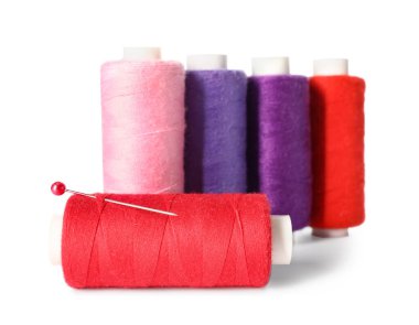 Beyaz zemin üzerinde iğne olan farklı dikiş iplikleri