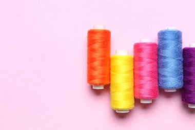 Pembe arka planda farklı dikiş iplikleri