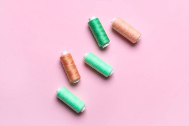 Pembe arka planda farklı dikiş iplikleri