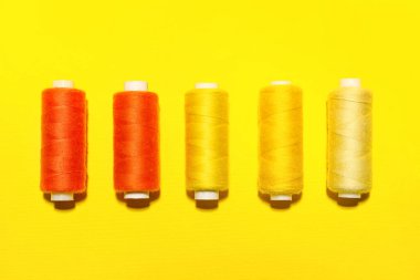 Sarı arkaplanda farklı dikiş iplikleri