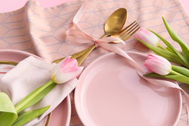 Pembe arka planda lale çiçekleri olan şık masa ayarları