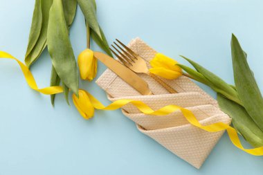 Mavi arka planda lale çiçekleri olan şık çatal bıçak takımı