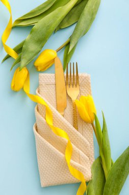 Mavi arka planda lale çiçekleri olan şık çatal bıçak takımı