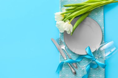 Mavi arkaplanda lale çiçekleri olan şık masa ayarları