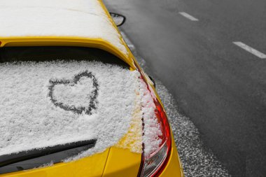 Kalp karla kaplı arabanın arka camına çizilmiş.