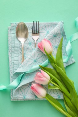 Turkuaz arka planda lale çiçekli şık çatal bıçak takımı