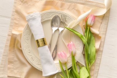 Hafif ahşap zemin üzerinde lale çiçekleri olan şık masa ayarları