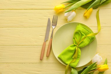 Ahşap zemin üzerinde lale çiçekleri olan şık masa ayarları