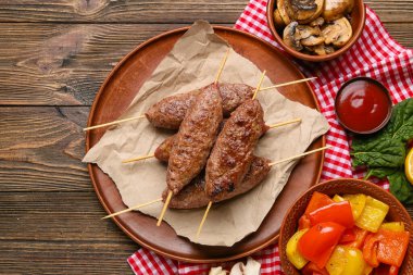 Lezzetli lula kebabı, ızgara sebze ve ahşap kaplama soslu şiş tabağı.